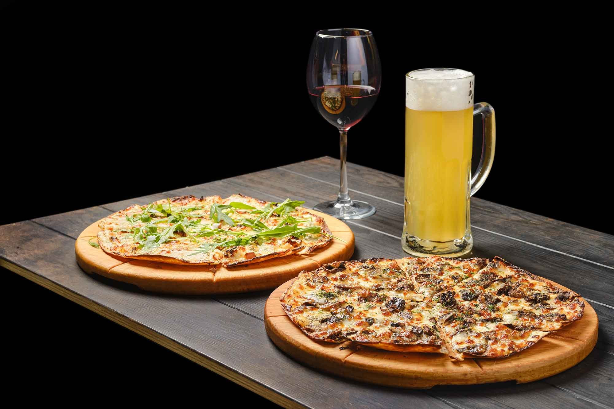 two-pizzas-and-a-glass-of-beer-and-red-wine-on-a-t-2023-11-27-05-29-36-utc